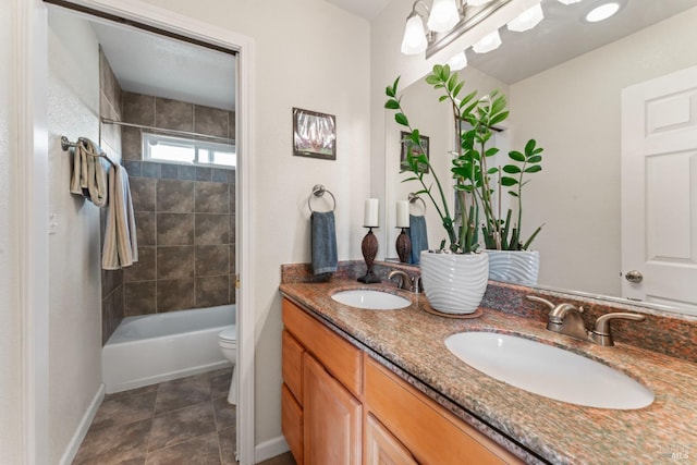 full bathroom with baseboards, toilet, double vanity, and washtub / shower combination