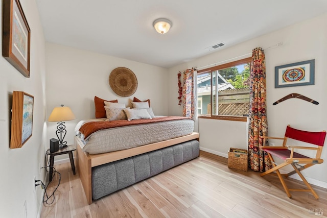 bedroom featuring wood finished floors and baseboards