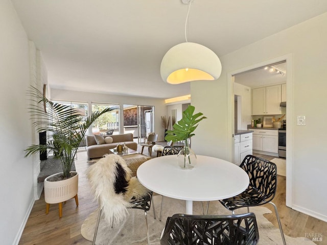 dining area with light wood finished floors and baseboards