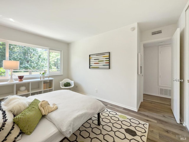 bedroom with light wood-style floors and baseboards