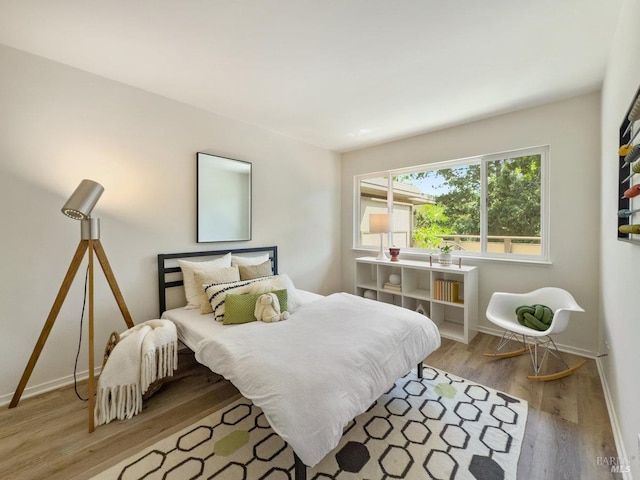 bedroom with wood finished floors and baseboards