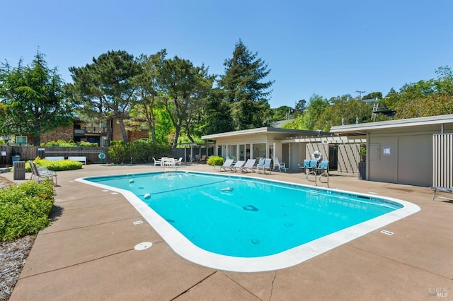 community pool featuring a patio and fence