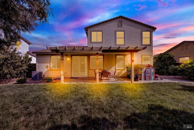 212 Via Del Sol, Vacaville, CA 95687 - back of property at dusk with stucco siding, a tiled roof, a patio, and a lawn