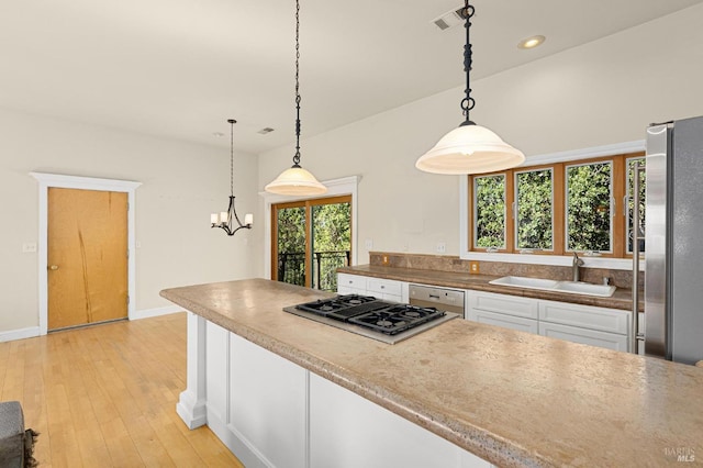 1126 Rimrock Dr, Napa, CA 94558 - kitchen with freestanding refrigerator, stovetop with downdraft, white cabinetry, dishwashing machine, and a sink