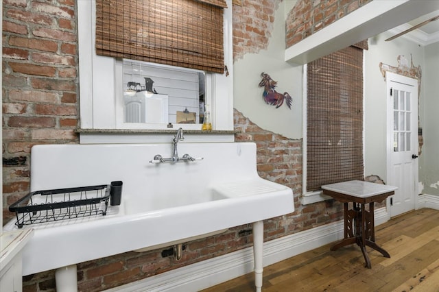 25107 Main St, Capay, CA 95607 - bathroom featuring wood-type flooring, baseboards, and brick wall