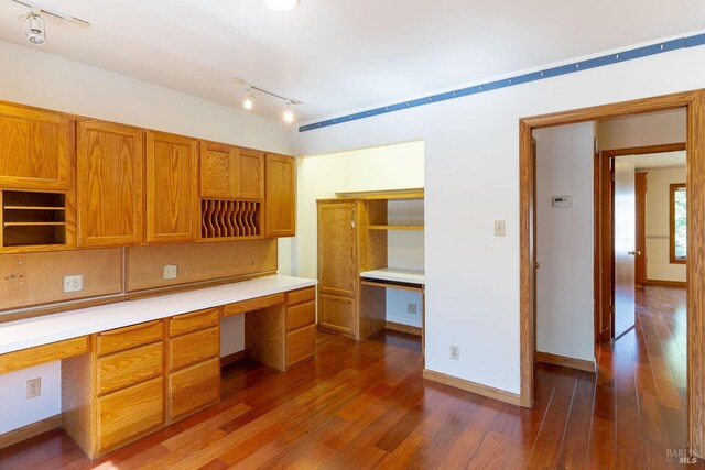 3756 Cano Ct, Napa, CA 94558 - unfurnished office with built in desk, dark wood-style floors, rail lighting, and baseboards