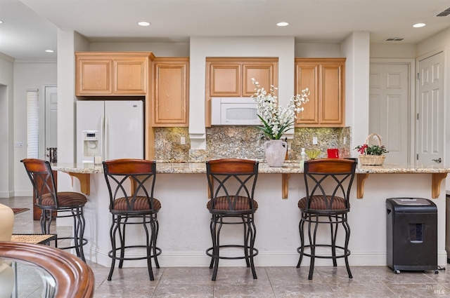 421 Redmont Ln, Rio Vista, CA 94571 - kitchen featuring white appliances, a breakfast bar area, tasteful backsplash, recessed lighting, and light stone countertops