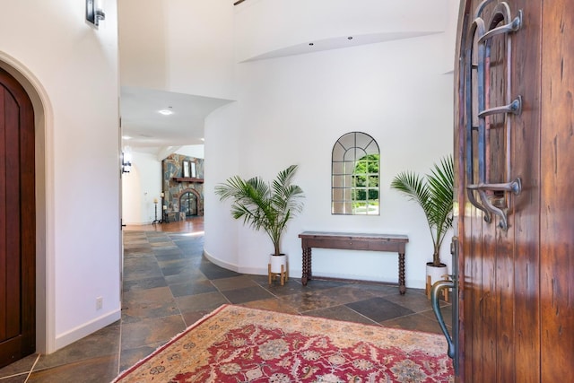 27681 Mace Blvd, Davis, CA 95618 - entrance foyer with stone tile floors, baseboards, arched walkways, and a towering ceiling