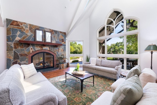 27681 Mace Blvd, Davis, CA 95618 - living area featuring high vaulted ceiling, wood finished floors, a stone fireplace, and plenty of natural light