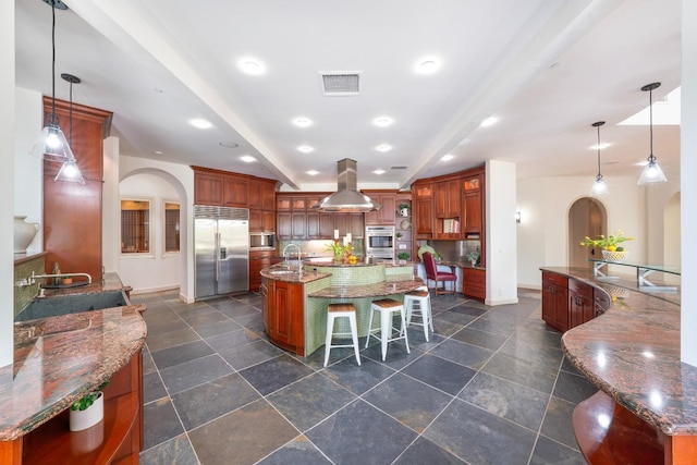 27681 Mace Blvd, Davis, CA 95618 - kitchen with built in appliances, a large island, island exhaust hood, arched walkways, and a breakfast bar