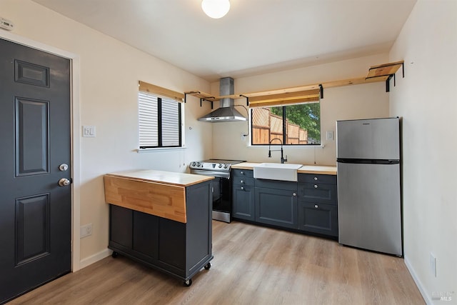 8940 Irving St, Graton, CA 95444 - kitchen with appliances with stainless steel finishes, wall chimney exhaust hood, open shelves, light wood finished floors, and a sink