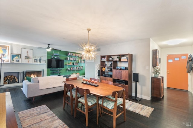 464 Azalea Way, Vacaville, CA 95688 - dining area featuring dark wood-style floors, a lit fireplace, a chandelier, ceiling fan, and baseboards