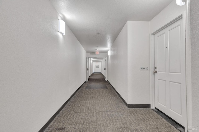 3183 Wayside Plz Unit 319, Walnut Creek, CA 94597 - hall with dark carpet, a textured wall, a textured ceiling, and baseboards