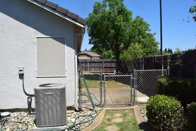 view of yard with central air condition unit and a gate