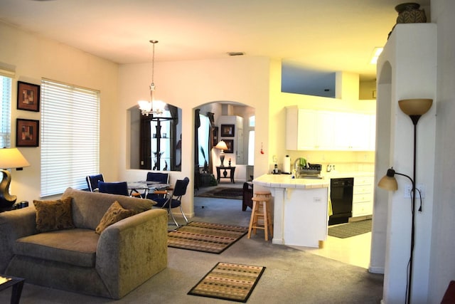 living area featuring arched walkways, light carpet, and a chandelier
