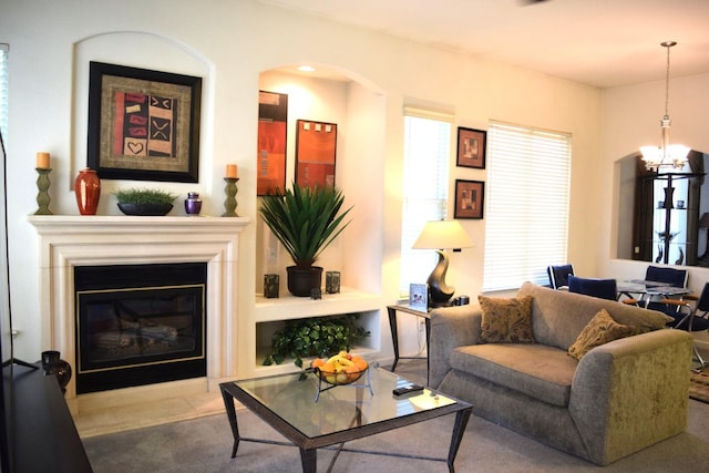 living room featuring a chandelier, a glass covered fireplace, and arched walkways