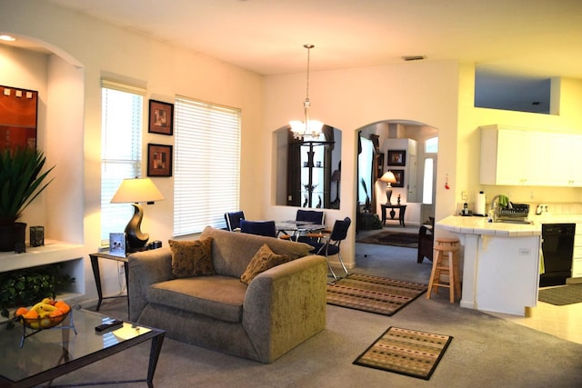 living room with arched walkways, carpet flooring, and a chandelier