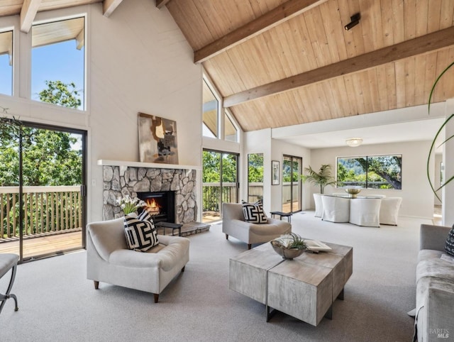 carpeted living area featuring wooden ceiling, high vaulted ceiling, beamed ceiling, and a stone fireplace