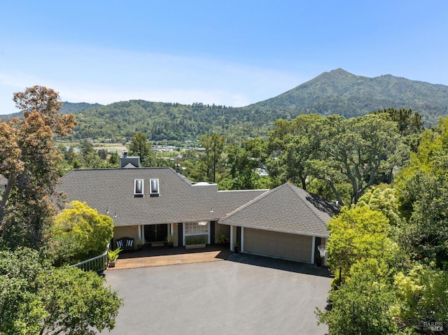 view of front of property with a garage, a mountain view, driveway, and roof with shingles
