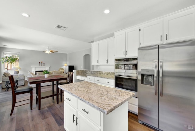 1917 Rollingwood Dr, Fairfield, CA 94534 - kitchen featuring stainless steel appliances, ceiling fan, a center island, dark wood-style flooring, and light stone countertops