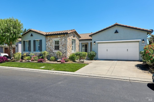 339 Desert Forest Ct, Rio Vista, CA 94571 - mediterranean / spanish house featuring driveway, a garage, a tiled roof, stucco siding, and stone siding