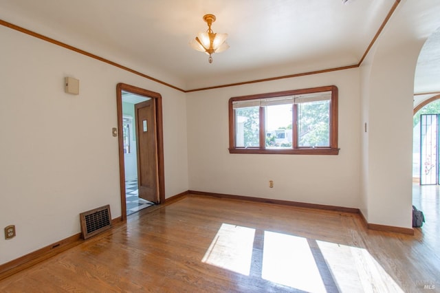 1124 Tuolumne St, Vallejo, CA 94590 - unfurnished room with arched walkways, wood finished floors, baseboards, and crown molding