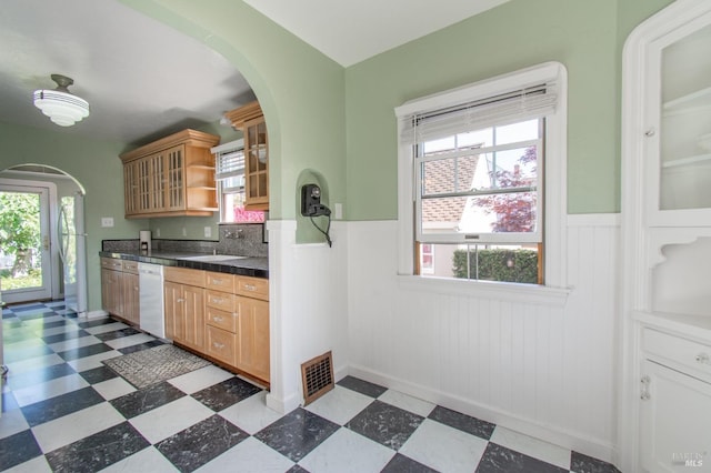1124 Tuolumne St, Vallejo, CA 94590 - kitchen featuring arched walkways, a wainscoted wall, healthy amount of natural light, dark countertops, and dark floors