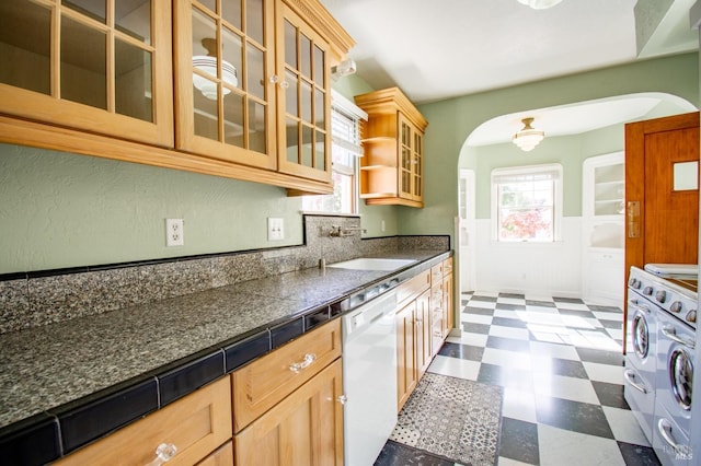 1124 Tuolumne St, Vallejo, CA 94590 - kitchen with arched walkways, white dishwasher, dark floors, dark countertops, and a wainscoted wall