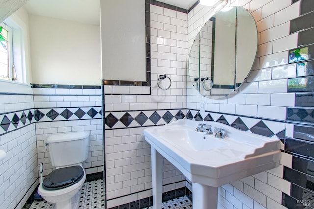 1124 Tuolumne St, Vallejo, CA 94590 - half bath featuring tile walls, toilet, a sink, and wainscoting