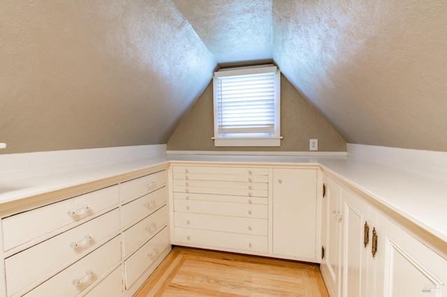 1124 Tuolumne St, Vallejo, CA 94590 - additional living space with a textured ceiling, light wood-type flooring, vaulted ceiling, a decorative wall, and wainscoting