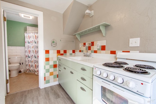 1124 Tuolumne St, Vallejo, CA 94590 - kitchen featuring white electric range oven, a sink, tile walls, a wainscoted wall, and light countertops