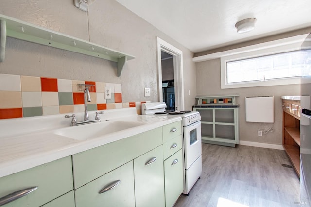 1124 Tuolumne St, Vallejo, CA 94590 - kitchen featuring green cabinets, white gas range, a sink, light wood-style flooring, and a textured wall