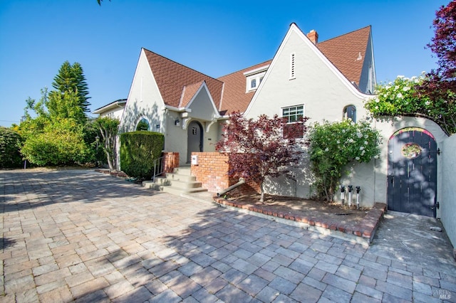 1124 Tuolumne St, Vallejo, CA 94590 - english style home featuring stucco siding, a chimney, and a shingled roof