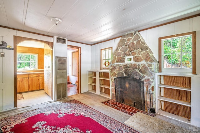1561 S Fitch Mountain Rd, Healdsburg, CA 95448 - unfurnished living room with a stone fireplace, arched walkways, crown molding, light carpet, and wood walls