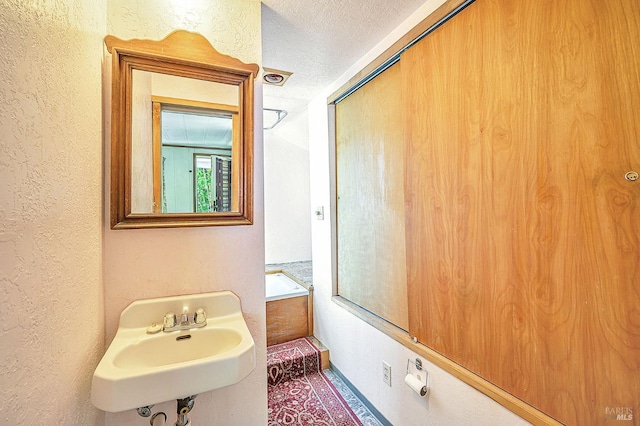 1561 S Fitch Mountain Rd, Healdsburg, CA 95448 - bathroom featuring a sink, a textured wall, and a textured ceiling