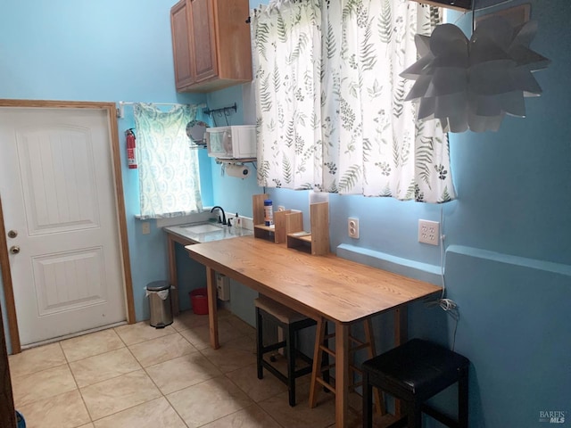 2499 Eastman Ln, Petaluma, CA 94952 - kitchen featuring light tile patterned floors, brown cabinets, and a sink