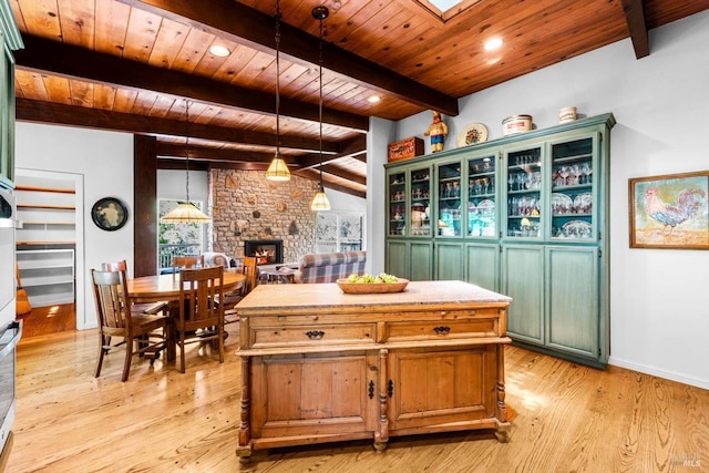 286 Monte Vista Dr, Napa, CA 94559 - kitchen with a stone fireplace, wooden ceiling with exposed beams, light wood-style flooring, hanging light fixtures, and a kitchen island
