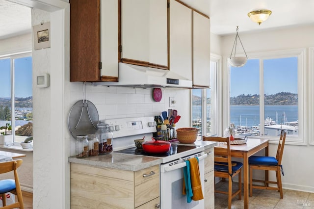 503 Easterby St, Sausalito, CA 94965 - kitchen featuring white electric stove, ventilation hood, light countertops, tasteful backsplash, and baseboards