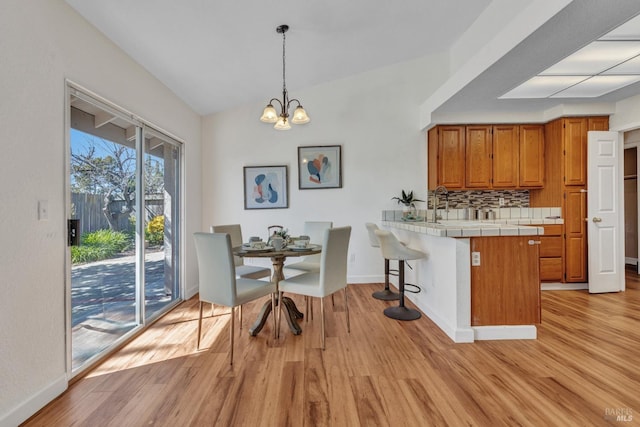 63 Brighton Dr, Vallejo, CA 94591 - dining space featuring light wood-style flooring, a chandelier, baseboards, and vaulted ceiling