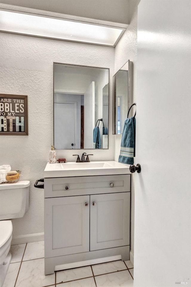 63 Brighton Dr, Vallejo, CA 94591 - half bath with marble look tile flooring, toilet, vanity, baseboards, and a textured wall