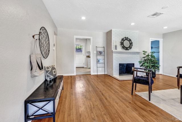 168 Bergwall Way, Vallejo, CA 94591 - living room featuring a fireplace, light wood-style floors, a textured ceiling, and recessed lighting