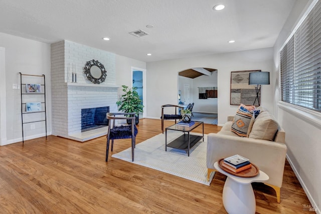 168 Bergwall Way, Vallejo, CA 94591 - living room with arched walkways, a brick fireplace, wood finished floors, recessed lighting, and a textured ceiling