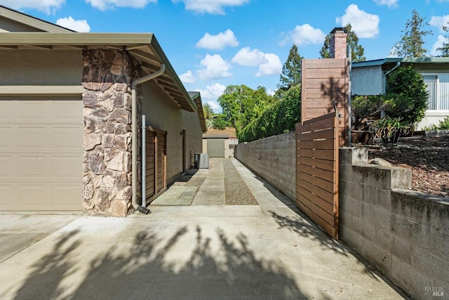 1006 Birkdale Dr, Napa, CA 94559 - view of side of property featuring fence, stucco siding, stone siding, a chimney, and a gate