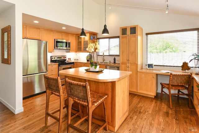 1006 Birkdale Dr, Napa, CA 94559 - kitchen featuring stainless steel appliances, vaulted ceiling, light countertops, light wood-style flooring, and track lighting