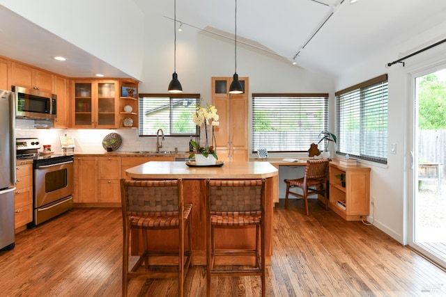 1006 Birkdale Dr, Napa, CA 94559 - kitchen featuring stainless steel appliances, lofted ceiling, light wood-style flooring, decorative backsplash, and a center island
