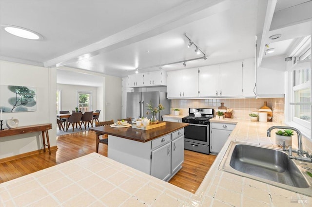 2787 N Fitch Mountain Rd, Healdsburg, CA 95448 - kitchen featuring appliances with stainless steel finishes, a sink, wood finished floors, tasteful backsplash, and white cabinets