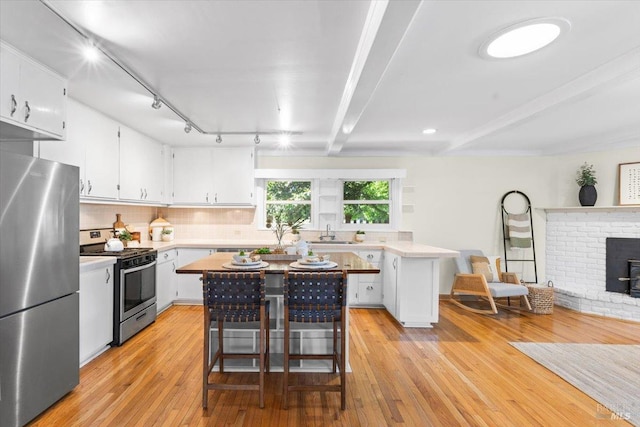 2787 N Fitch Mountain Rd, Healdsburg, CA 95448 - kitchen with stainless steel appliances, a sink, light countertops, white cabinets, and light wood-style flooring