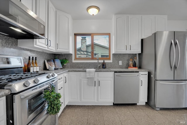 kitchen featuring stainless steel appliances, a sink, decorative backsplash, white cabinetry, and granite floors