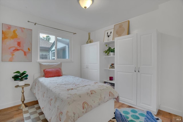 bedroom with light wood finished floors and baseboards