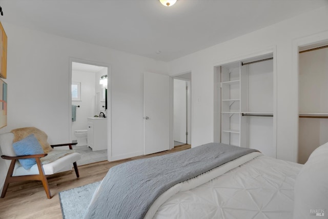 bedroom featuring light wood-style flooring and ensuite bathroom